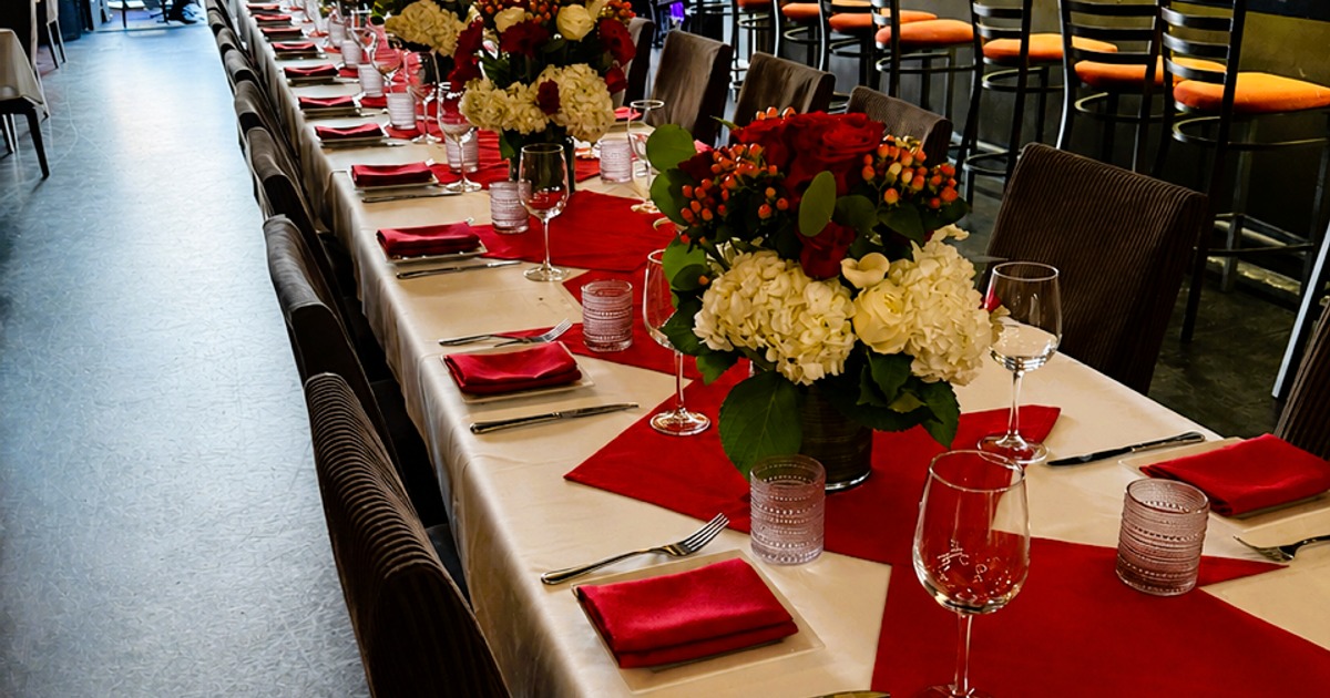 Long banquet table with floral centerpieces for a celebration dinner at Il Sogno Italiano.