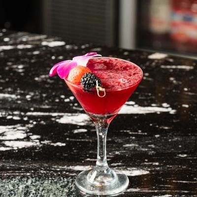 The Pomegranate drink garnished with purple flower and berries.