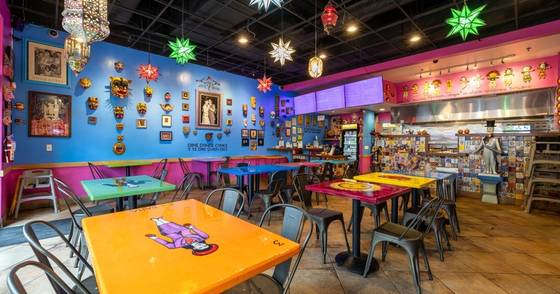 A colorful restaurant interior with decorated blue and pink walls
