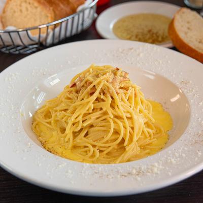 Spaghetti Carbonara, with bacon, onion, and egg in a blended cheese sauce.