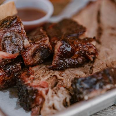 Sliced beef brisket with a dark bark on a tray, close up.