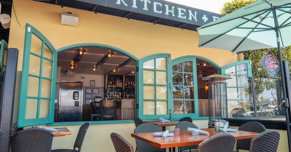 Outdoor dining tables by a turquoise window
