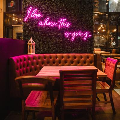 Private booth seating with artificial grass on the wall and neon light decoration