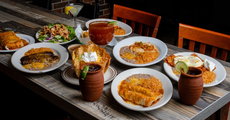 Assorted dishes on adiner table, chair behind and small part of interior