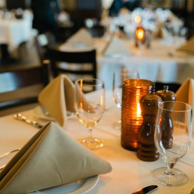 Table set with side plates, cutlery, glasses and glass candle holder.