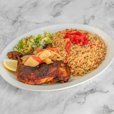 BBQ chicken meal featuring sides of rice, salad and a lemon wedge.