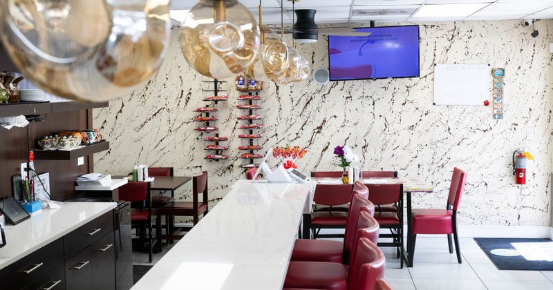 Interior, bar and seating area, marble top bar with stools, tables with chairs in the back