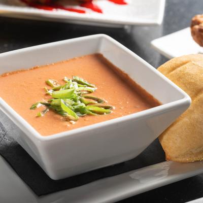 Bowl of House made Tomato Bisque, served with a bread roll.