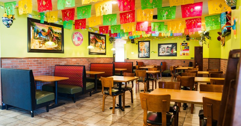 Interior, dining area, tables with chairs, seating booths, framed paintings on the walls