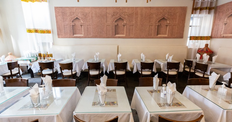 Cozy interior dining area with small dining tables set for two guests