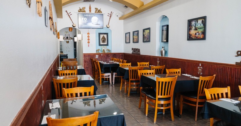 Interior, seating area, black cloth tables for two, four and six with a glass top