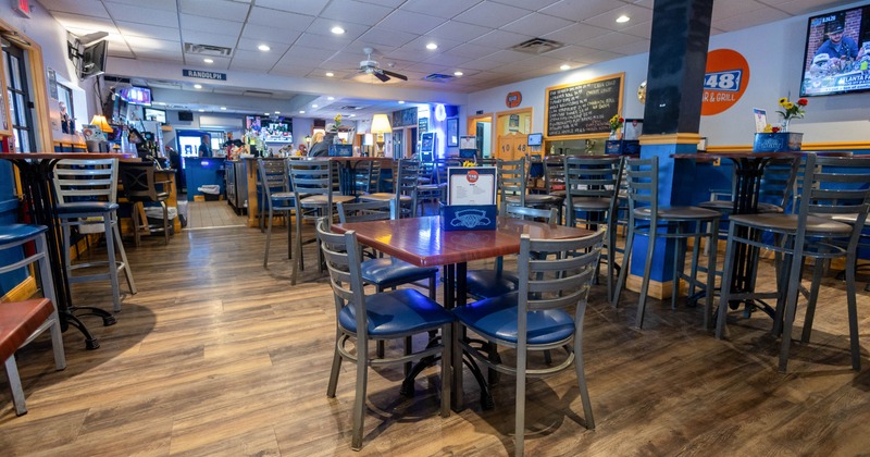 Spacious bar and grill with high top seating and TVs