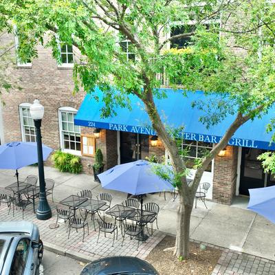 Tables and chairs under parasols outside of the restaurant.