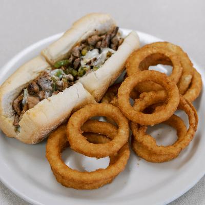 Philly Sub sandwich served with onion rings.