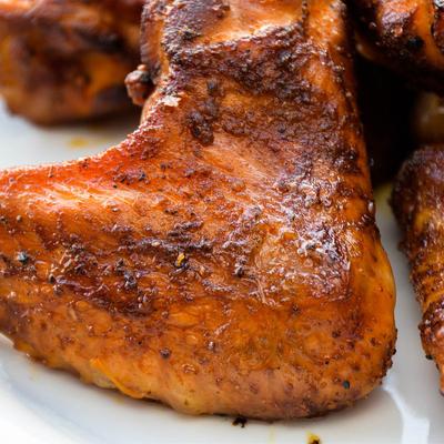 Grilled chicken quarter served on a white plate.