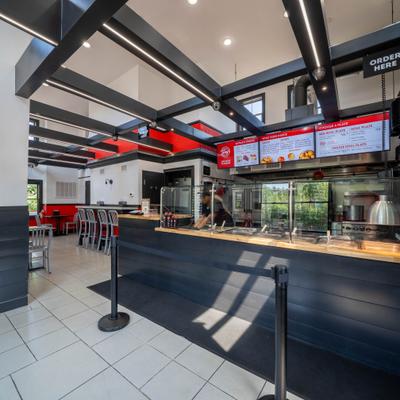 Interior with tilled floor, a dark counter and multiple digital menus.