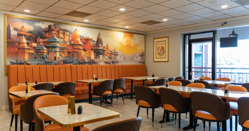 Interior, dining area with tables, booths and a large painting on the wall