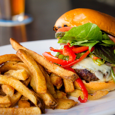 Cheeseburger, with tomato, red peppers, spinach and a side of fries photo.