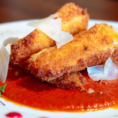 Deep-fried brie cheese on marinara sauce, topped with Parmesan and bacon.
