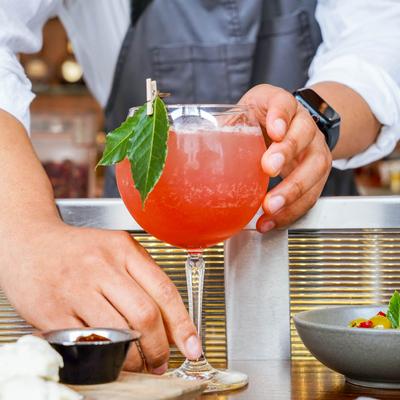 An employee placing a Thorne cocktail on the table.