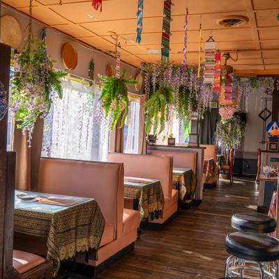 Restaurant booths with hanging flowers and lanterns.