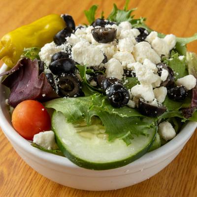 Small Greek Salad featuring pepperoncini pepper and crumbled feta cheese.