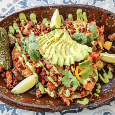 Crispy tortillas topped with steak, chorizo, bacon, avocado, and cilantro.