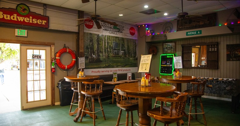 Cozy interior seating area with wooden round high tables and wooden stools