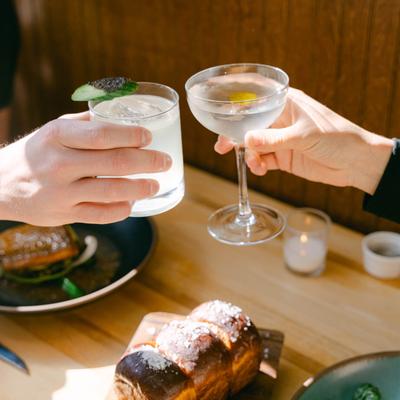 Hands holding clinking glasses.