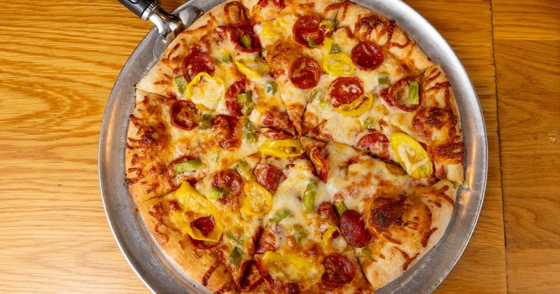 A pizza with cheese, pepperoni, and peppers