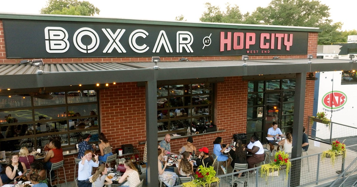 Storefront featuring signage, entrance and outdoor seating with string lights