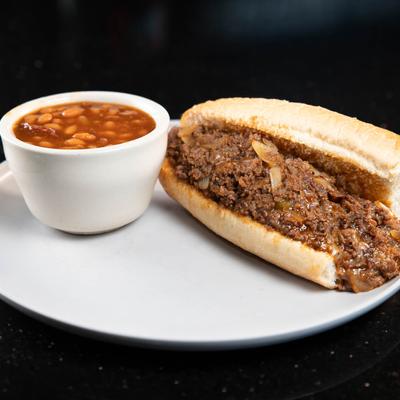 Philly Cheesesteak with a side of baked beans.