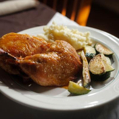 Roasted Chicken served with mashed potatoes and vegetables.