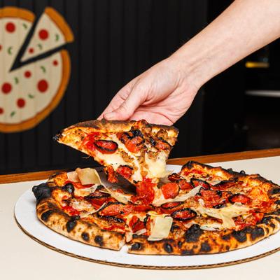 Hand taking a slice of Keuka Pizza from the plate.