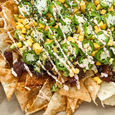 Tuna Poke Wonton Nachos, with avocado, mango, sesame seeds, jalapenos, and chili mayo.