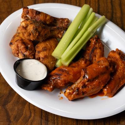 Chicken Wings served with celery sticks and a dipping sauce.