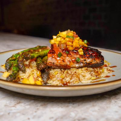 Citrus salmon served over rice with asparagus and mango pico de gallo.