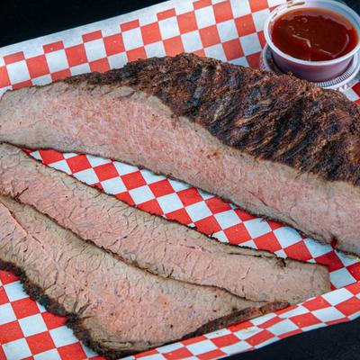 Smoked brisket served on a classic red-and-white checkered tray liner.