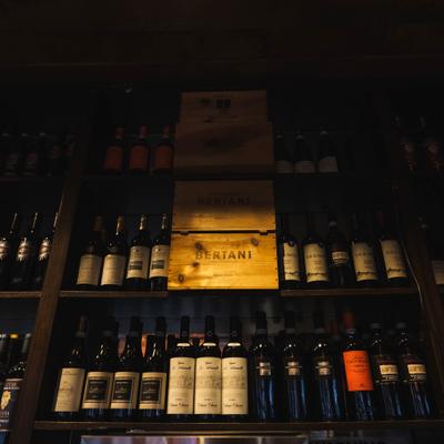 Dimly lit wine shelves with assorted bottles.