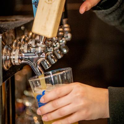 Hands pouring a drink from the dispensary.