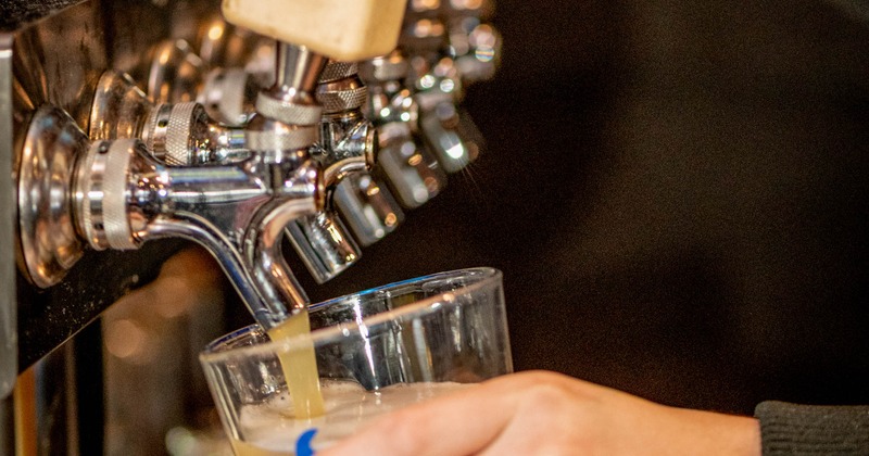 Hands pouring a drink from the dispensary