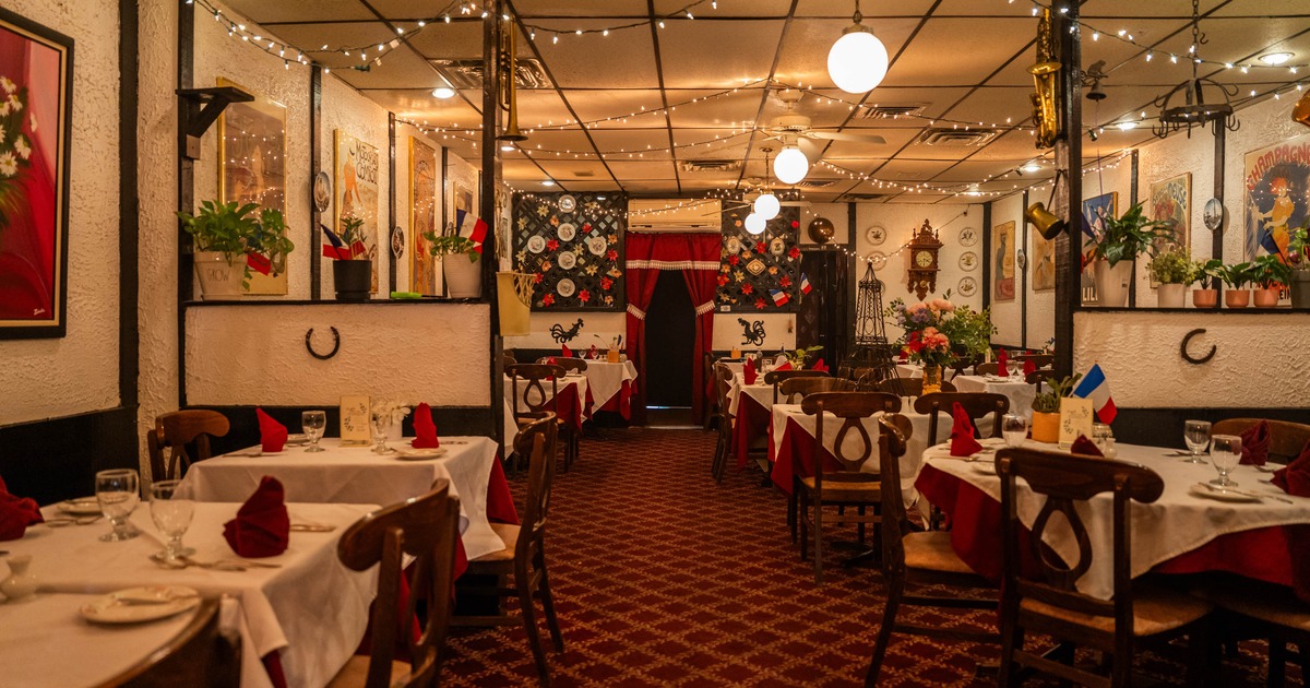 Interior seating area with tables set for dining, vintage posters on the walls