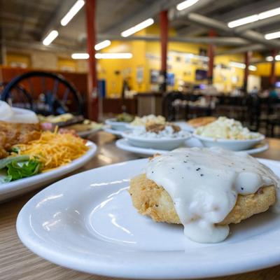 Country fried steak with gravy is in the foreground, surrounded by assorted dishes.
