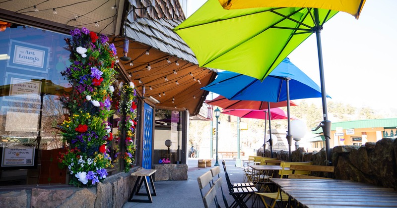 Outdoor patio cafe with colorful parasols, floral decorations, and tables