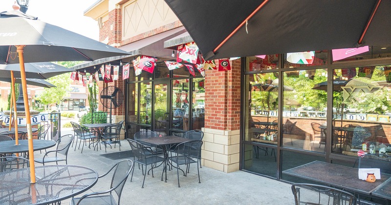 Outdoor seating area, tables, chairs, and black parasols