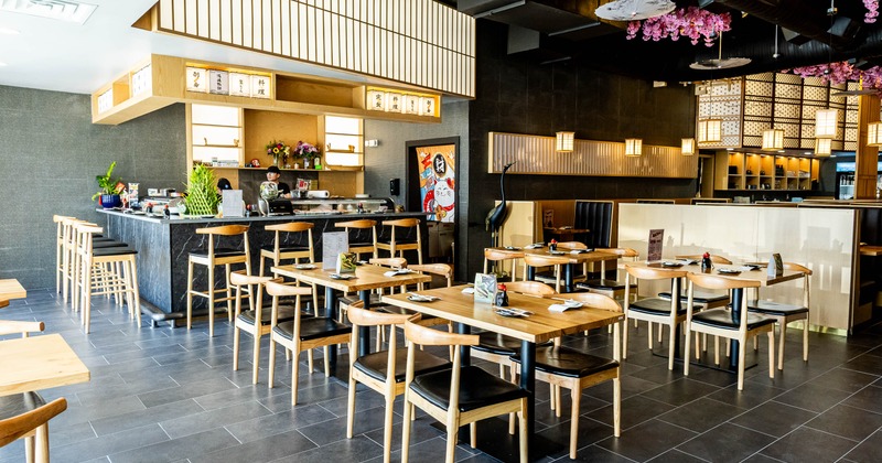A Japanese-style interior - tables, chairs, a service counter, paper umbrellas, cherry blossoms