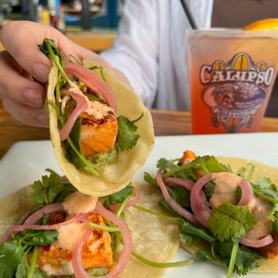 Fish tacos, with pickled red onion, cilantro, and sauce.