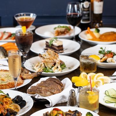 A table set with a large spread of a variety of dishes and drinks.