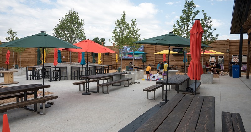 Outdoor seating area, a conjoined tables and benches, and colorful parasols