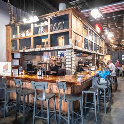 Interior, bar with guests sitting at the counter and staff in action.